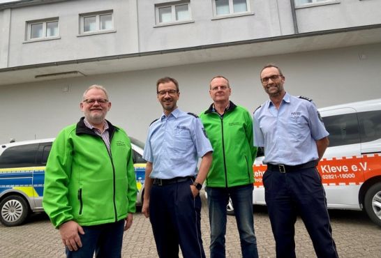 das Bild zeigt Falk Neutzer, Achim Jaspers, Peter Baumgarten und Thomas Hermes-Jansen vor einem Streifenwagen bzw. einem Fahrzeug der Verkehrswacht